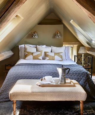 attic bedroom with double bed with footstool under the eaves