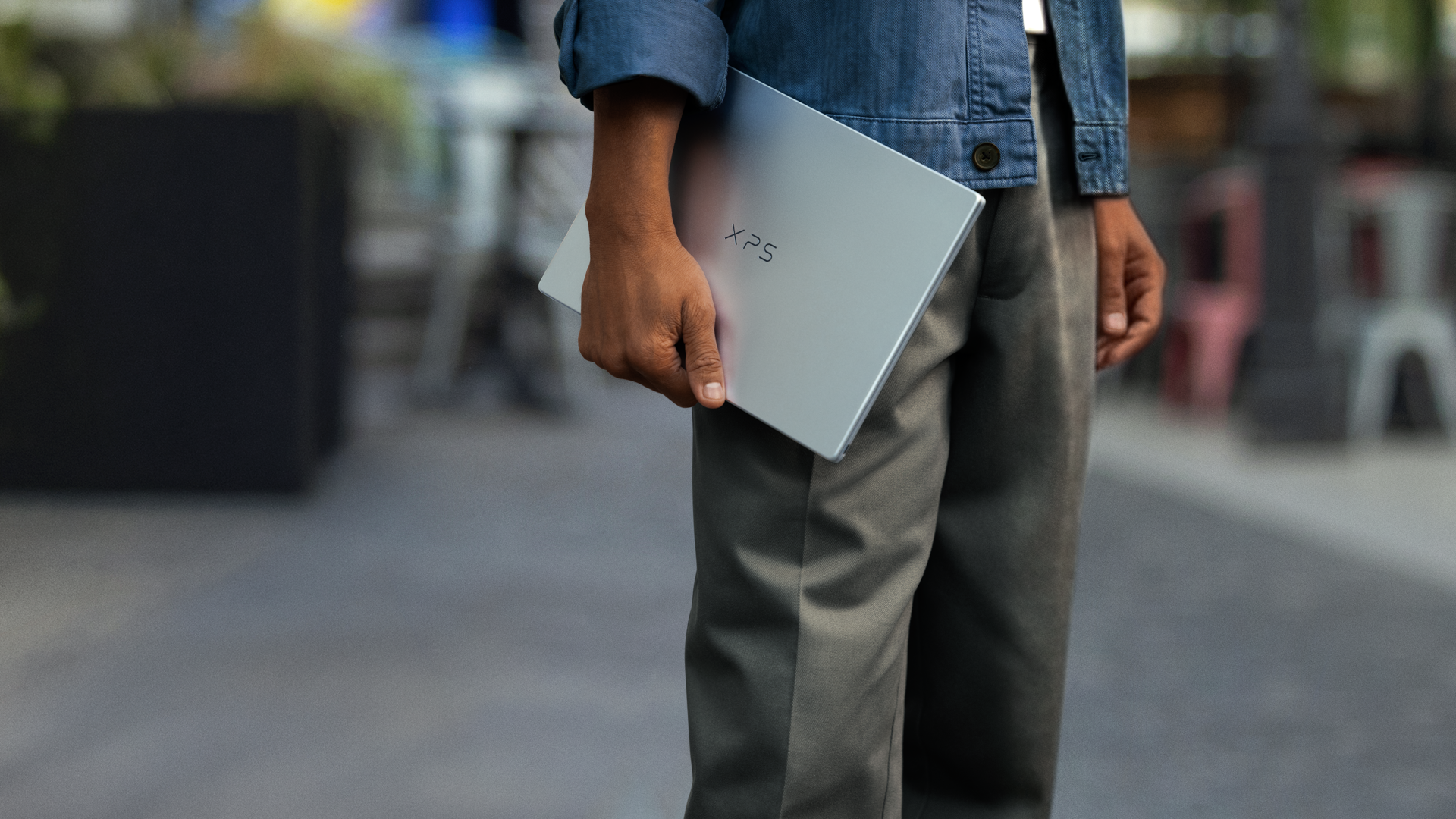 Dell XPS 13 laptop being carried in one hand