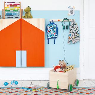 An IKEA playroom with a wall storage cabinet and colour-blocked pattern