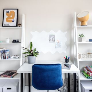 Akuko Atelier Refugee Home with blue chair potted plant and white wall
