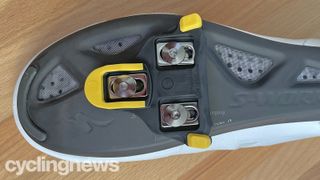 A close up of the yellow Shimano cleats fitted to a shoe, showing the cleat's overall size and width