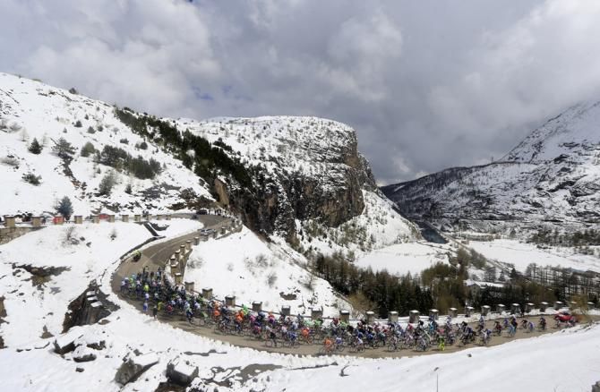 The snow capped mountains surround the peloton