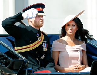 Prince Harry, Duke of Sussex and Meghan, Duchess of Sussex travel down The Mall in a horse drawn carriage during Trooping The Colour 2018 on June 9, 2018 in London