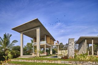 the sculptural open concrete spaces in this India home helps it commune with nature