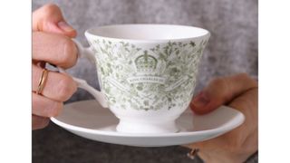 A King Charles coronation white-and-green cup and saucer.