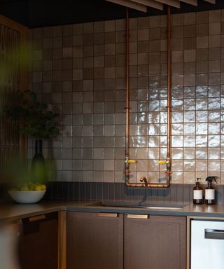 A brown kitchen decorated with three different textured tiles