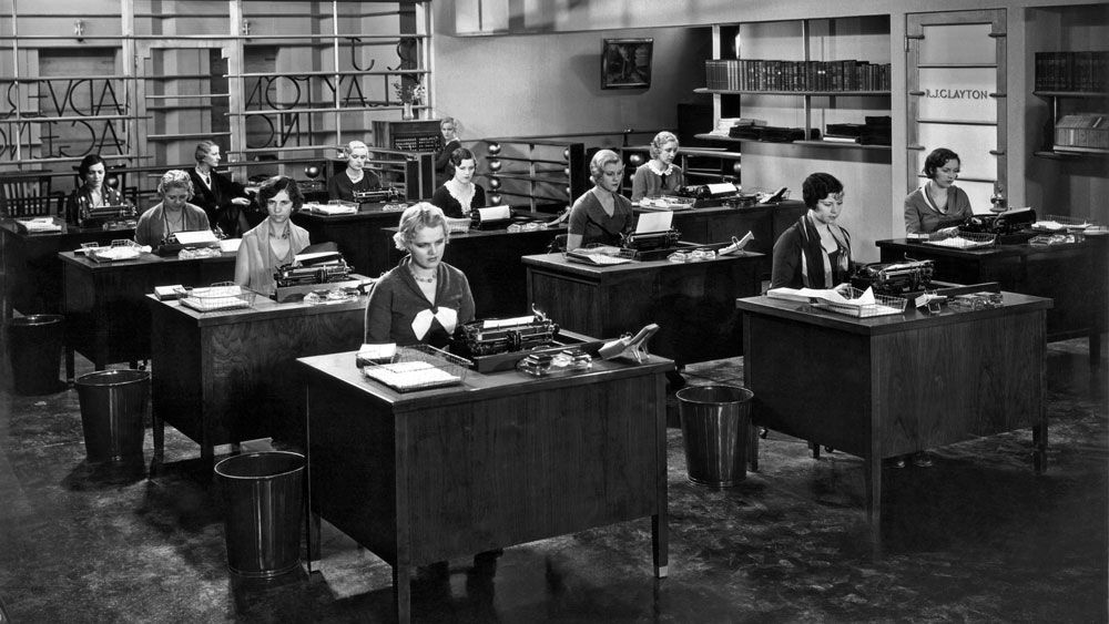 Black and white image of secretaries in an office room