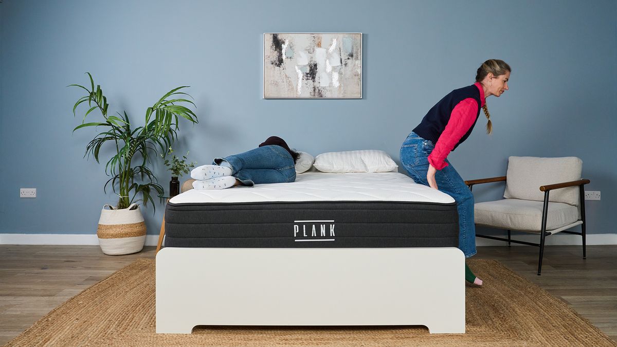 Becky George lies on the Plank Firm Luxe mattress in our Sleep Lab, while Nicola Appleton climbs onto the bed to test motion isolation