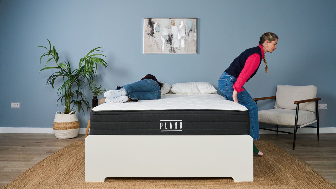 Becky George lies on the Plank Firm Luxe mattress in our Sleep Lab, while Nicola Appleton climbs onto the bed to test motion isolation