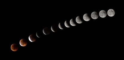 This combination of 14 pictures put together in photoshop and taken on July 27,2018 shows the moon during a total lunar eclipse.
