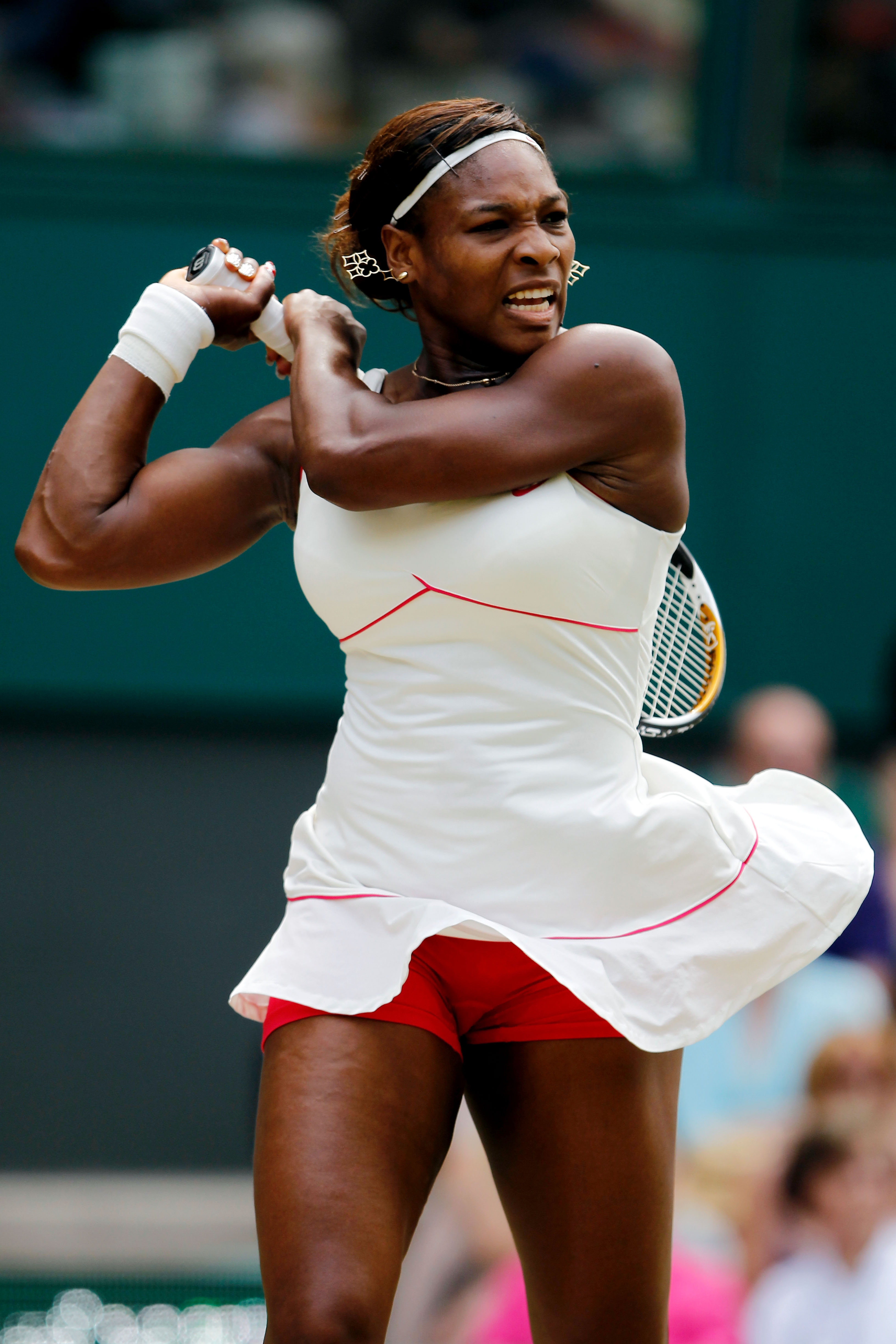 Serena Williams wore a white tennis dress with peekaboo red shorts at Wimbledon 2010