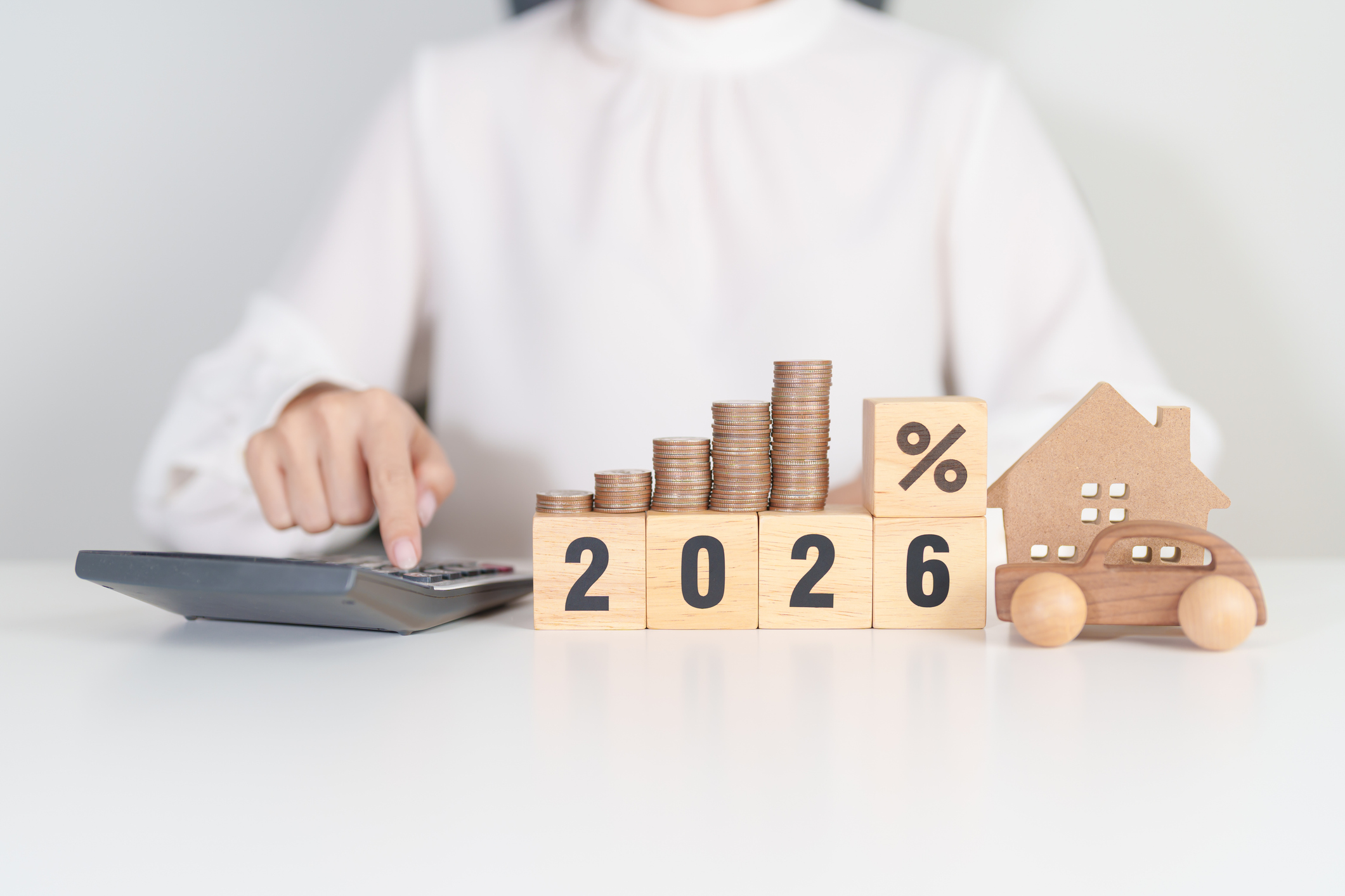 2026 New Year with percentage change to UP and Down arrow, car and Home model with coin stack.