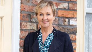 Sue Cleaver as Eileen Grimshaw standing outside house on Coronation Street