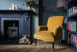 contrasting yellow chair in blue living room with fireplace