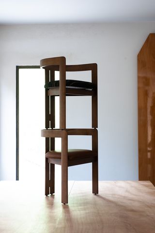 Two versions of Tobia Scarpa's Pigreco chair stacked on top of each other on a table