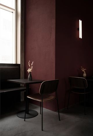 Brown chair with coffee table next to a maroon wall