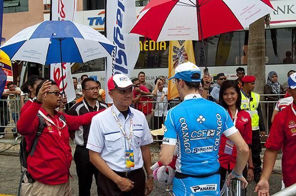 Stage winner Marco Canola (Colnago CSF Inox) is protected from the rain as he leaves the podium in Kuantan.