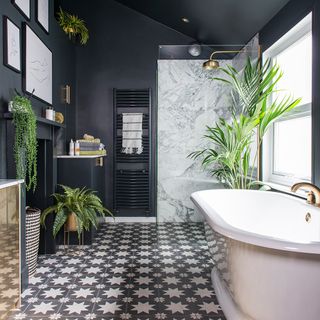 black bathroom with bathtub and potted plants