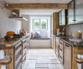 Modern farmhouse kitchen in cottage with low ceilings, wooden cabinets and black upper cabinets