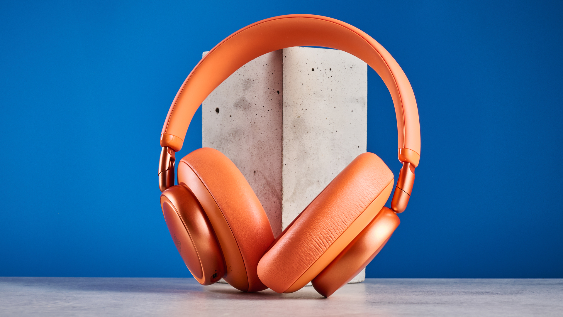 the jbl live 780NC in orange photographed against the blue tom's guide background