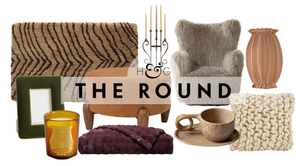 Cozy decor, including a plush bath mat, velvet picture frame, scented candle, Bubble Cuddle Throw Blanket, boucle ottoman, candelabra, mug and saucer set, sherpa chair, ruched sconce, and knit pillow