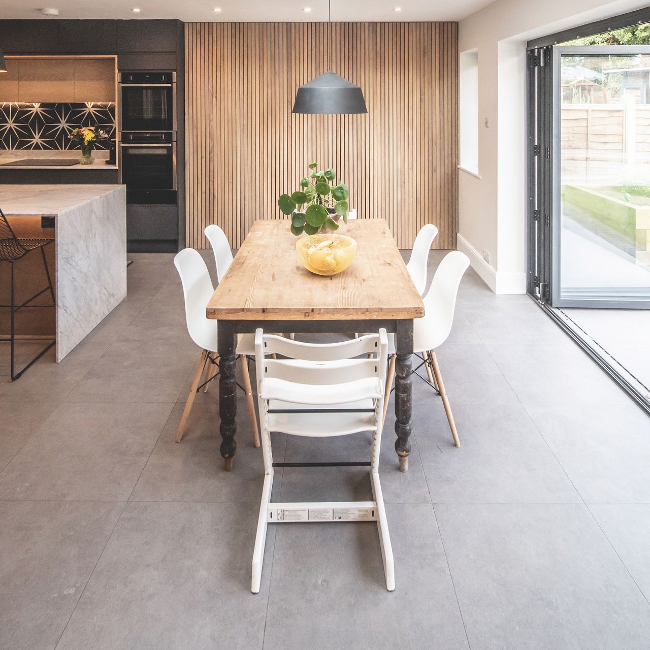 The oak wood panelling gives warmth to the black matt black handleless kitchen.