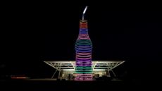 A giant soda sculpture is illuminated in front of Pops 66 in Oklahoma