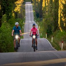 Two people riding bikes along a road