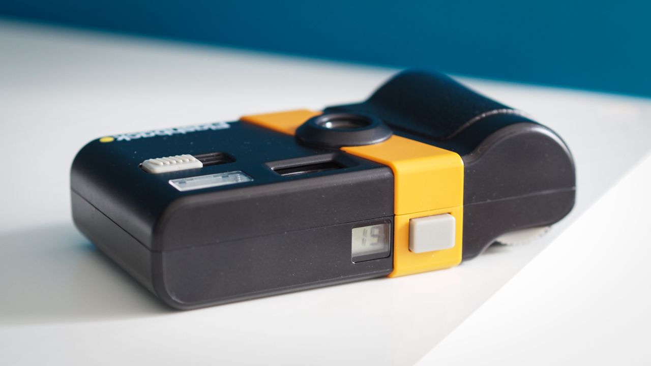Lifestyle photo of the Flashback camera against a light blue background