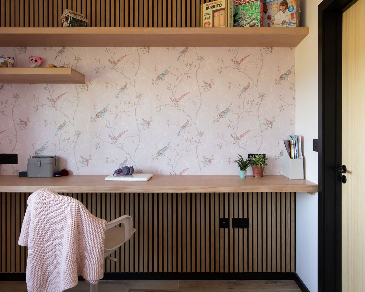 An area inside the home with detailed wallpaper with pink tones