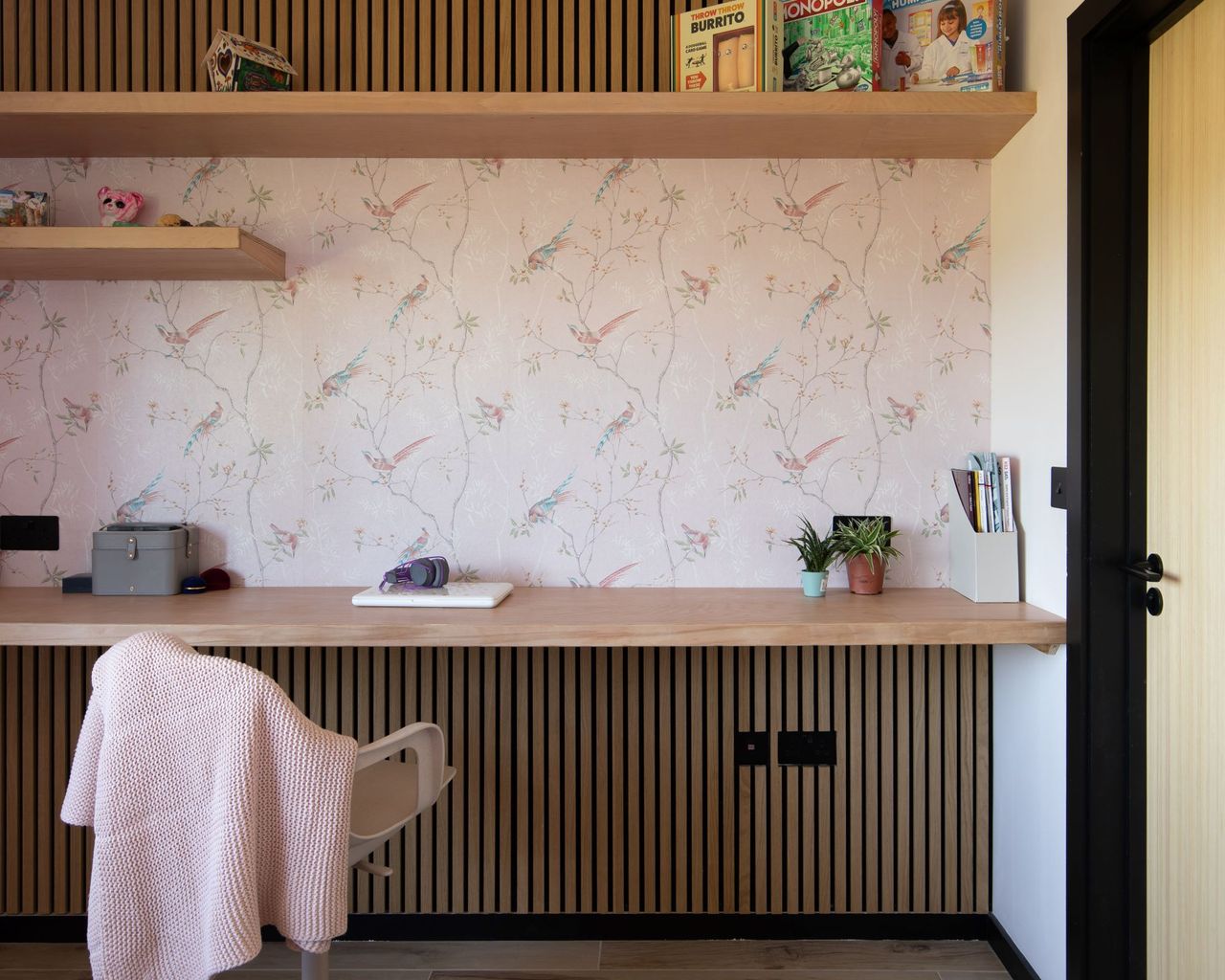 An area inside the home with detailed wallpaper with pink tones