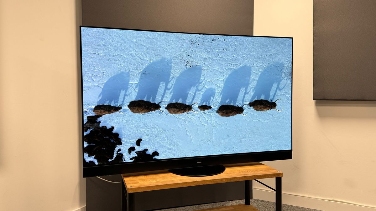 The Panasonic MZ2000 TV on a TV stand, with a line of elephants seen from above on screen.