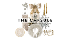 White and gold Christmas decor, including a frosted white wreath, metal chainmail stocking, crystal napkin ring, and a tree donning an oversized bow