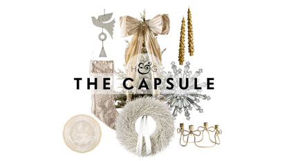 White and gold Christmas decor, including a frosted white wreath, metal chainmail stocking, crystal napkin ring, and a tree donning an oversized bow