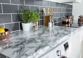 kitchen dark with grey brick wall and spatulas potted plant on marble