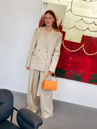 Lady in a large suite holding a bag