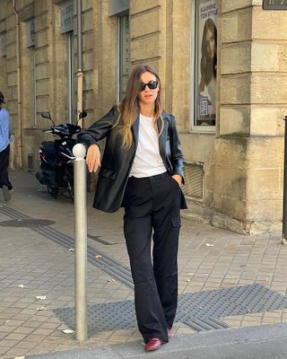 Die französische Mode-Influencerin Anne-Laure Mais trägt in Paris ein schickes Herbstoutfit mit schwarzen Hosen.