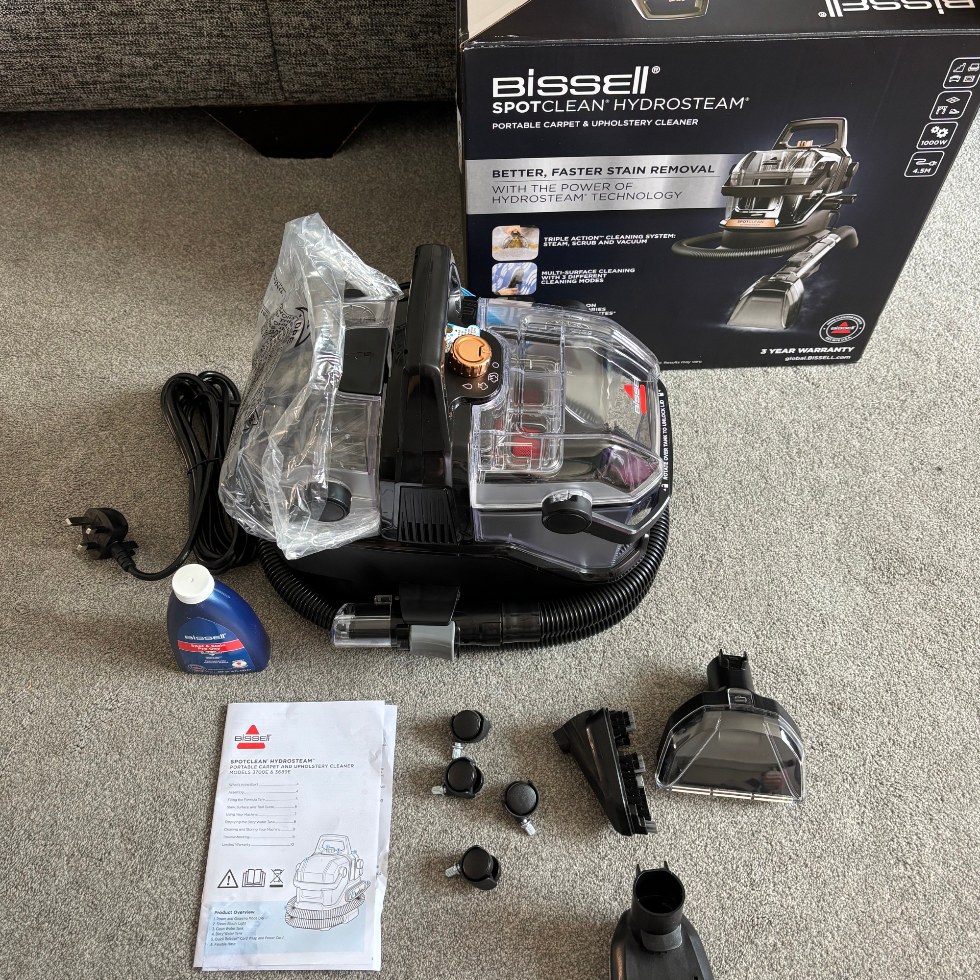 Flat lay of Bissell SpotClean HydroSteam and accessories out of box