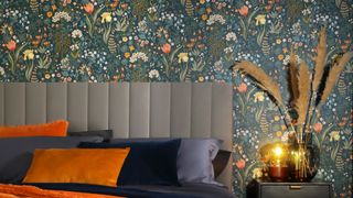 Bedroom trend with dark botanical wallpaper behind a grey velvet headboard