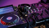 A pair of DJ headphones sat on a mixer