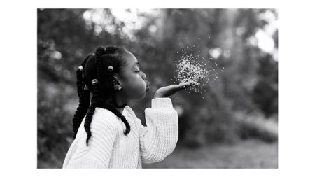 Photograph of a girl blowing seeds from her hand, taken by family photographer Helen Bartlett, one of the speakers on the Canon Spotlight stage at The Photography & Video Show 2026