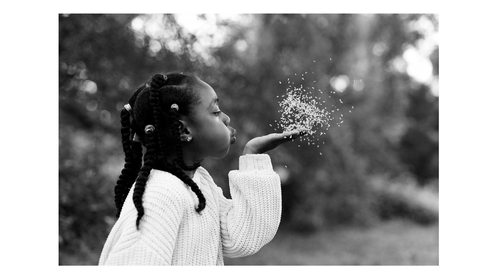 Photograph of a girl blowing seeds from her hand, taken by family photographer Helen Bartlett, one of the speakers on the Canon Spotlight stage at The Photography &amp; Video Show 2026