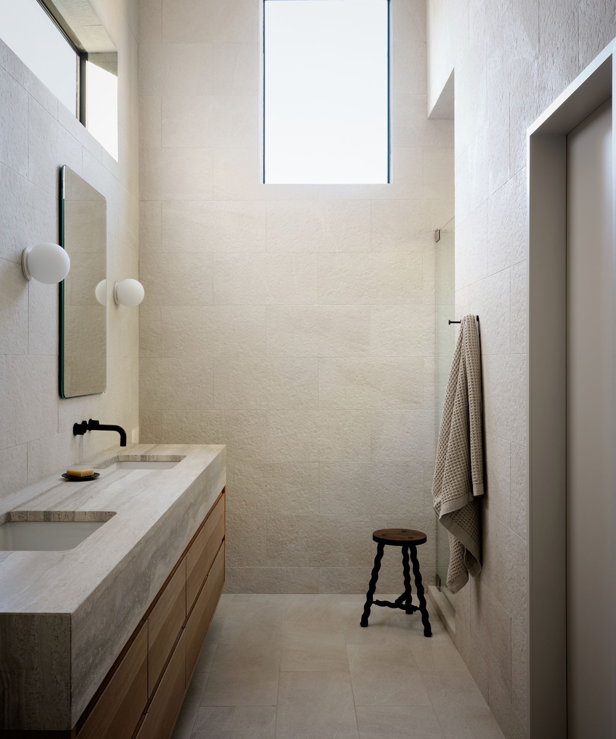 japandi bathroom with marble and wooden vanity and a small stool