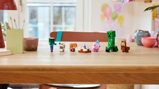 Lego Baby Pig's Birthday Celebration figures on a table, in a line