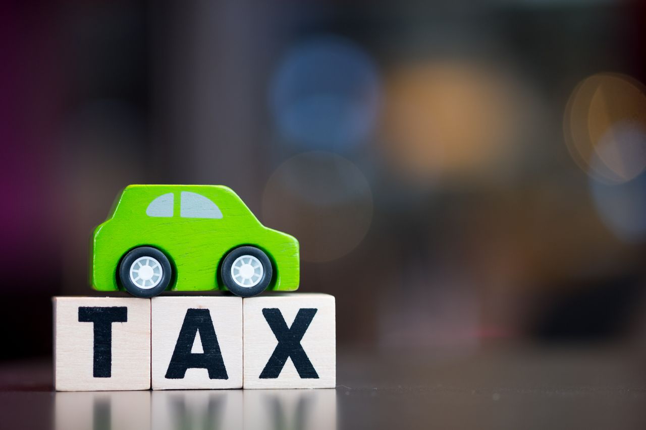 rendering of a small green car on a sign that says tax