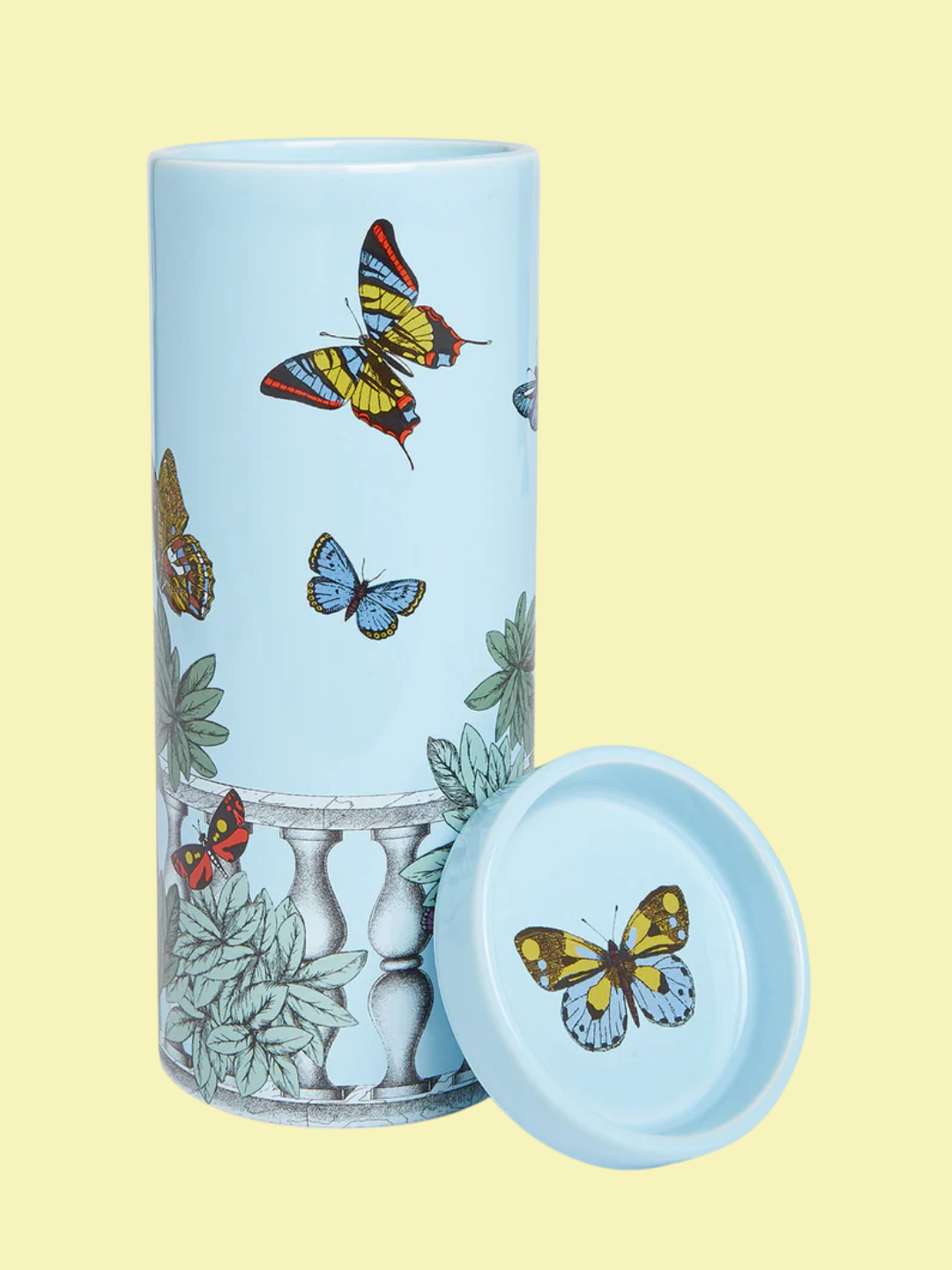 A tall pillar scented candle in a blue patterned vessel from Fornasetti