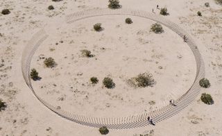 Aerial view of The Circle of Land and Sky, 2017, by Phillip K Smith III. A circle made of glass bars in the desert sand.