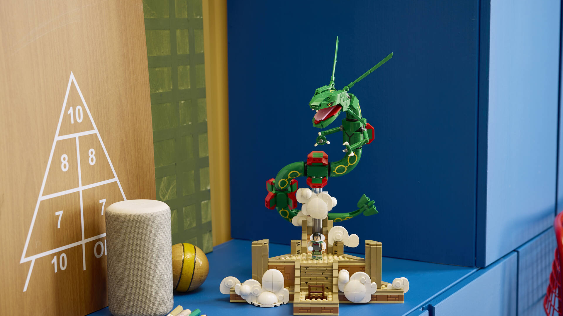 Lego Rayquaza set on a blue sideboard, with a triangle of numbers on a wall beside it