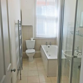 Beige and white coloured bathroom with shower cubicle