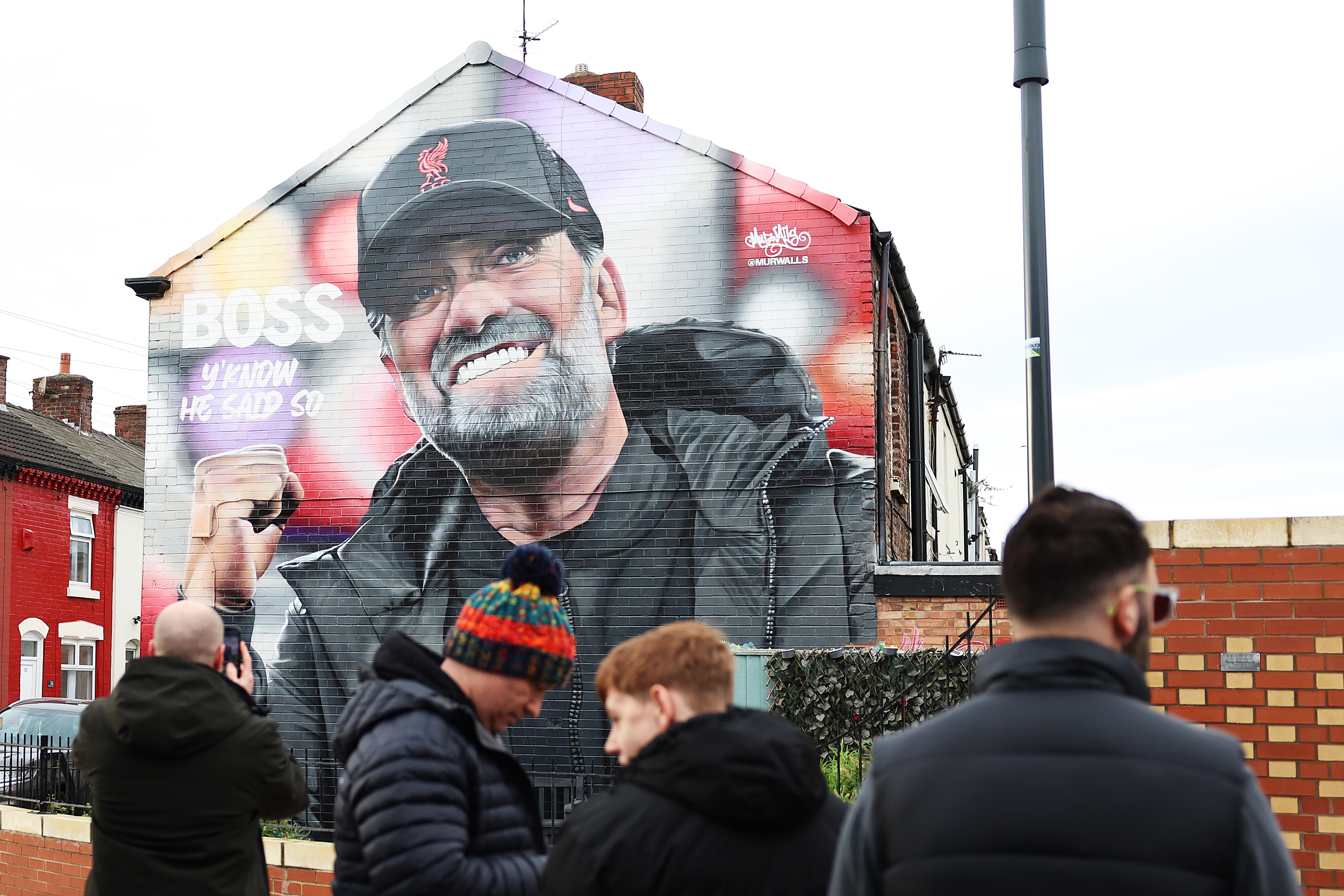 Liverpool fans walk past a Jurgen Klopp mural following the German's shock announcement that he is leaving the Reds at the end of the 2023/24 season.